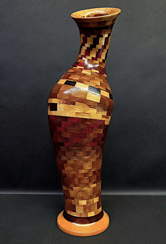 Wooden vase with a mosaic pattern on a dark background