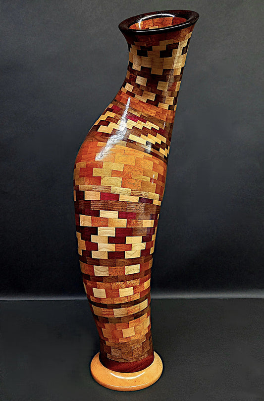 Multicolored wooden patterned vase on a dark background