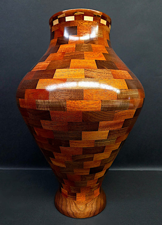 Wooden vase with a patchwork design on a dark background