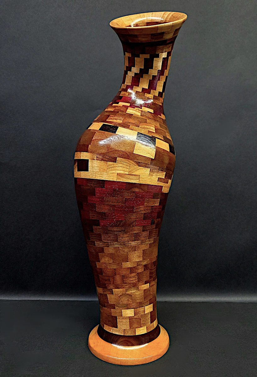 Wooden vase with a mosaic pattern on a dark background