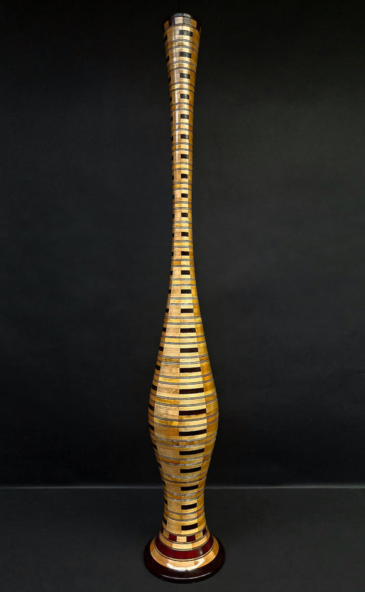 Tall, intricately designed wooden vase on a black background